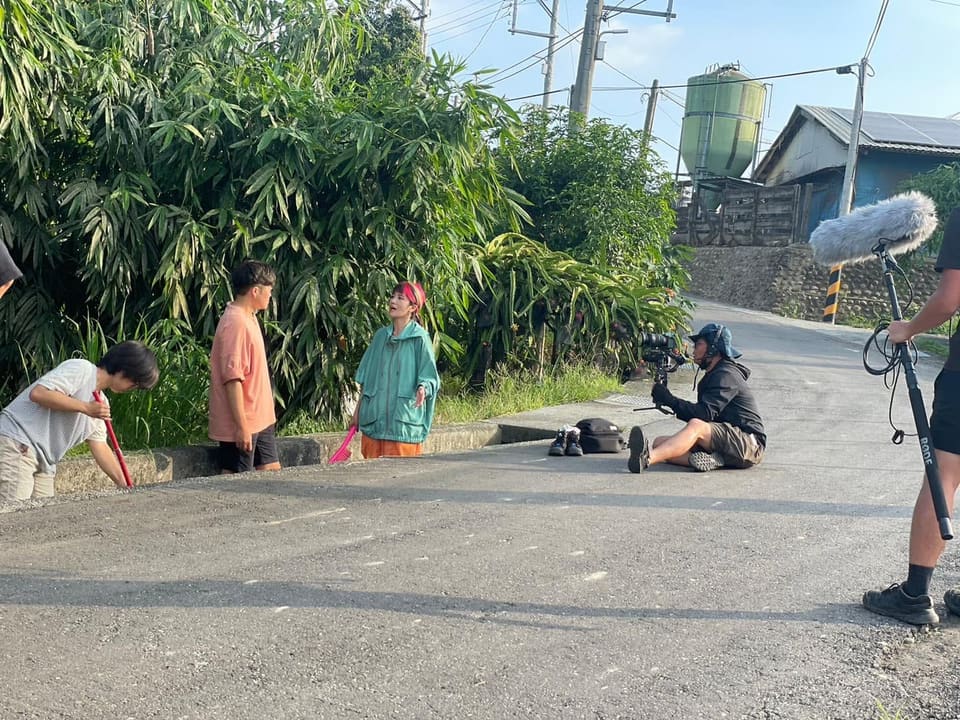 攝影與收音團隊在道路旁進行拍攝